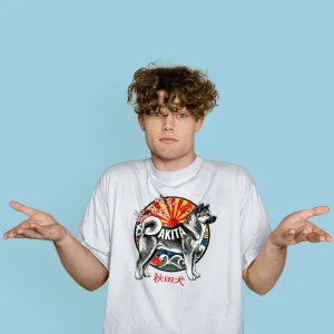 A young man wears a white Oversize T-shirt with a bold Akita design inspired by Japanese art, pairing comfort with cultural style